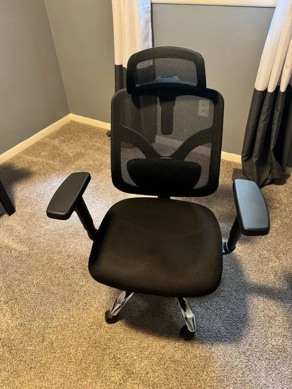 Black desk chair w/ headrest and mesh comfort perfect for the 8+ hours of conference calls. Adjustable if you can figure out the levers & knobs.