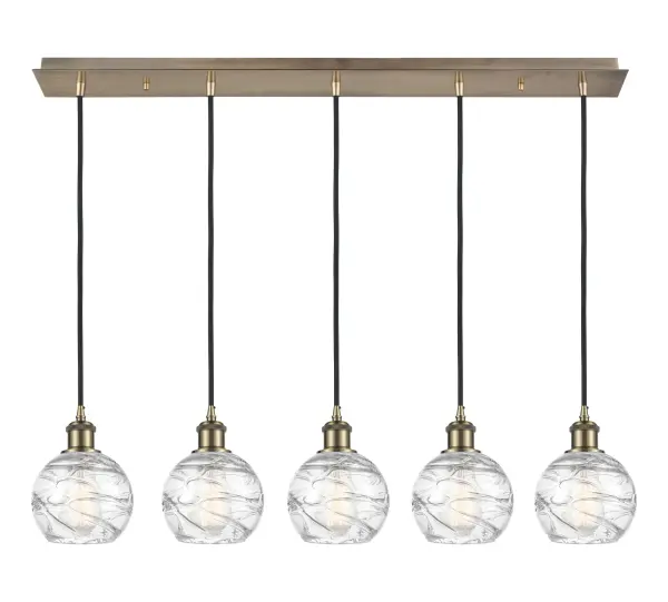 The organic teardrop shape of the Crown Point pendant is artfully hung from a tiered metal frame that is complemented by a single filament bulb. These pendants look great as individual fixtures but make a grand statement when paired with our multi-port hanging system as part of our custom cord program.