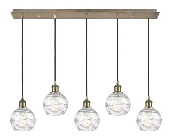 The organic teardrop shape of the Crown Point pendant is artfully hung from a tiered metal frame that is complemented by a single filament bulb. These pendants look great as individual fixtures but make a grand statement when paired with our multi-port hanging system as part of our custom cord program. - alternate view