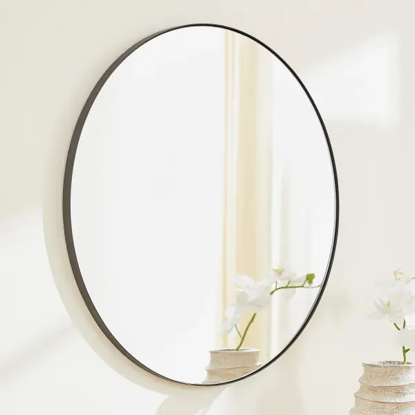This 30-inch round mirror features a sleek matte black frame that complements any modern or contemporary décor. Its clean, simple design makes it a versatile choice for residential and commercial spaces alike. - alternate view