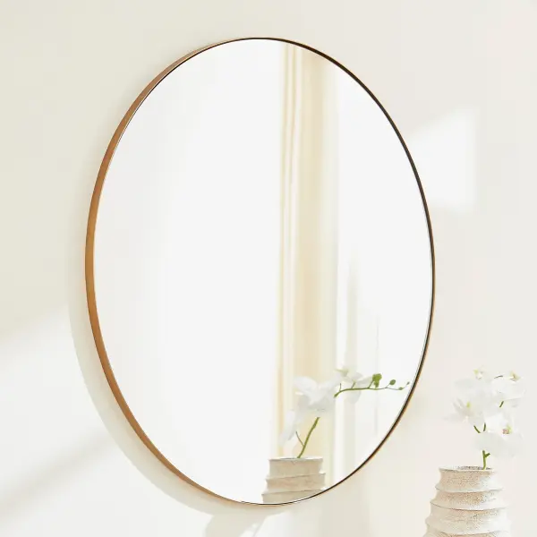 This 36-inch round mirror features a sleek gold frame that brings warmth and elegance to any space. Its clean, simple design makes it adaptable to various décor styles from contemporary to transitional settings. - alternate view