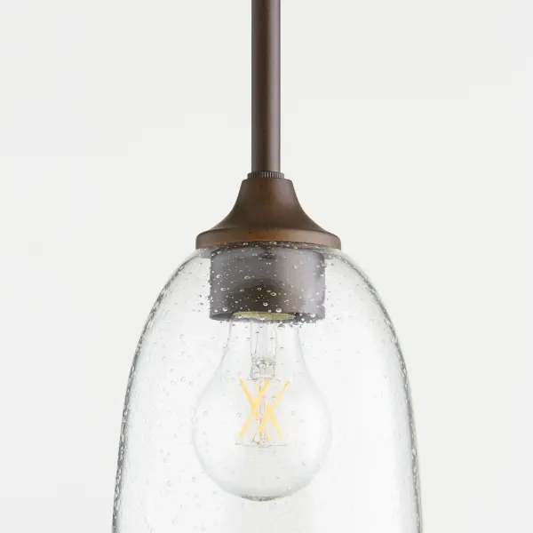 The Jardin mini pendant combines intricate finials and soft curves with an oiled bronze finish and clear seeded glass shade. Its refined yet approachable design offers versatility for various spaces. - alternate view