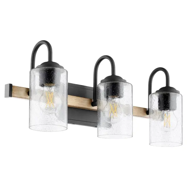 The Pepper Glass 3-Light Vanity combines rustic farmhouse appeal with industrial edge through its two-toned Driftwood/Noir finish and clear seeded glass shades. Perfect for creating vintage-inspired bathroom ambiance with modern functionality.