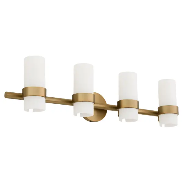 The Sojourn 4-Light Vanity blends contemporary lines with nostalgic charm, featuring candle-like white milky glass pillars and a modern bobeche detail. The brushed brass finish adds warmth and sophistication to bathrooms and powder rooms.