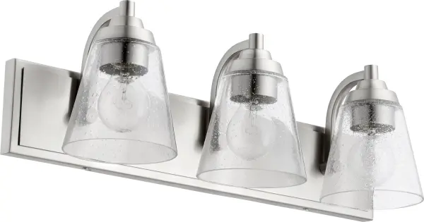 This 3-light vanity fixture combines classic round elements with a modern rectangular backplate, creating a balanced design that works in any bathroom style. The satin nickel finish and clear seeded glass provide both elegance and functionality.
