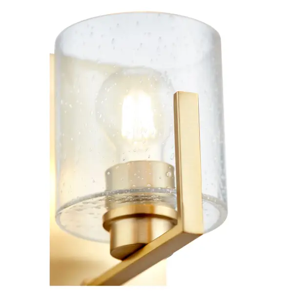 This single-light wall sconce combines classic seeded glass with warm aged brass for a versatile fixture that works in traditional and transitional spaces. The rectangular backplate and round shade create visual interest. - alternate view