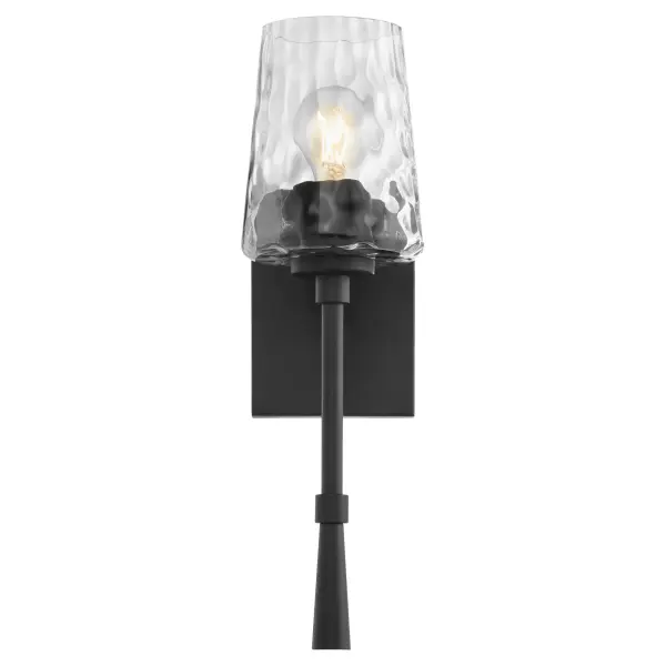 The Goodwin wall sconce combines sleek matte black framing with textured hammered glass for a sophisticated look. Its single-light design provides focused illumination perfect for hallways, bathrooms, and accent lighting. - alternate view