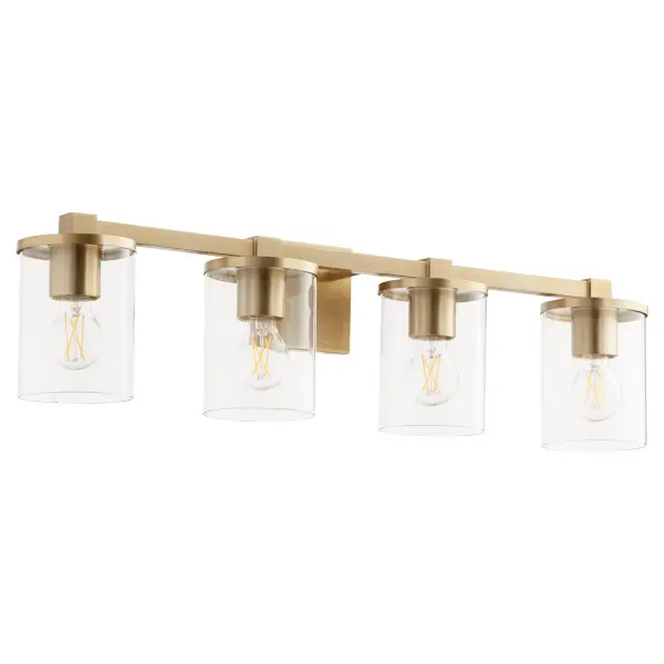 The Bolton vanity light combines crisp angles and clean details with aged brass finish and clear cylindrical glass shades. Perfect for modern bathrooms seeking sophisticated illumination with contemporary flair.