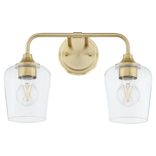 The Raymond 2-Light Vanity combines simple elegance with practical functionality. Featuring tapered clear glass shades and aged brass finish, this fixture delivers warm, ambient lighting perfect for bathrooms and powder rooms.