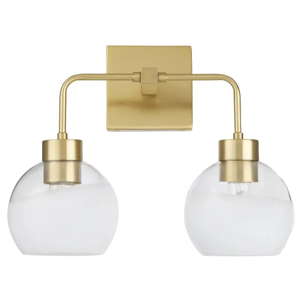 The Lacy 2-Light vanity fixture combines artisanal layered white glass shades with aged brass hardware for a sophisticated transitional look. Each hand-dipped shade creates unique flowing lines while slim rods and rounded corners soften the geometric square backplate.