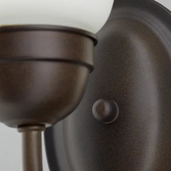 This elegant single-light wall sconce combines graceful round elements with classic detailing in a warm Oiled Bronze finish. Perfect for adding ambient lighting and traditional charm to hallways, bedrooms, and bathrooms. - alternate view