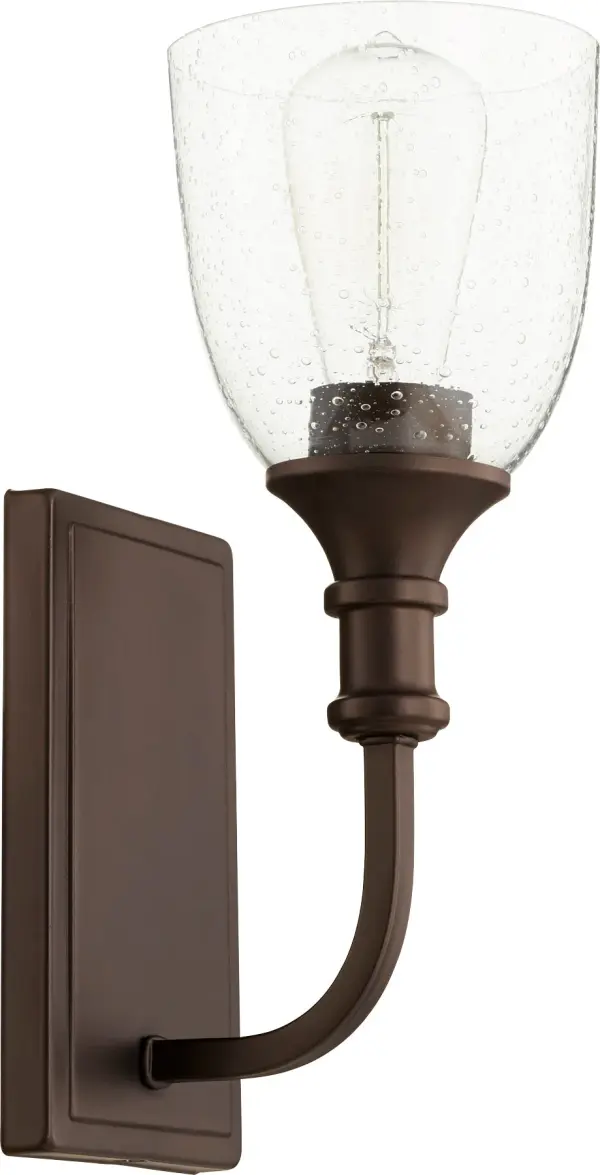 The Richmond wall sconce blends traditional design with playful semicircular arms and clear seeded glass. Its oiled bronze finish and versatile style make it perfect for hallways, bathrooms, and bedrooms.