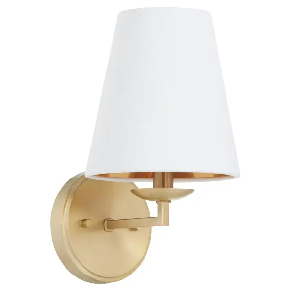 The Karnes wall sconce by Tamara Day brings classic sophistication with its aged brass finish and white linen shade featuring a gold interior lining. Perfect for adding warm ambient lighting to any space.