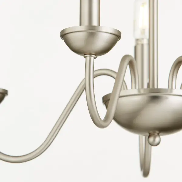 This 5-light chandelier combines graceful curves with a sleek satin nickel finish, delivering classic traditional style at an accessible price point. Its neutral metallic tone adapts beautifully to various color schemes. - alternate view