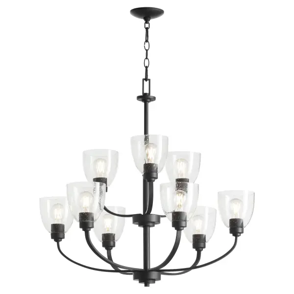 The Reyes 9-light chandelier combines sleek textured black finish with clear seeded glass for a sophisticated transitional look. Its clean-lined design blends seamlessly with various aesthetics while making a statement. - alternate view