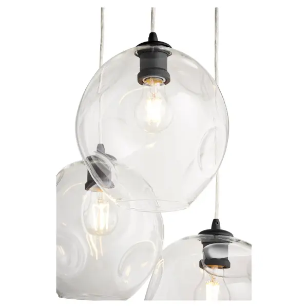 The Numen 3-Light Pendant brings modern sophistication with its black metal construction and distinctive wavy glass globes. The cluster design creates visual interest while providing ample illumination for dining and living spaces. - alternate view