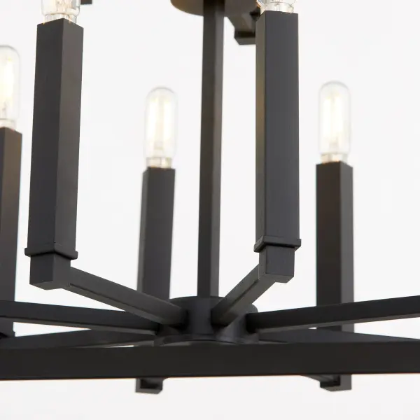 The Manor chandelier delivers impressive illumination with 12 lights in an open-frame design. Its noir black finish and interchangeable candle sleeves offer flexibility for various design schemes, from modern farmhouse to transitional spaces. - alternate view