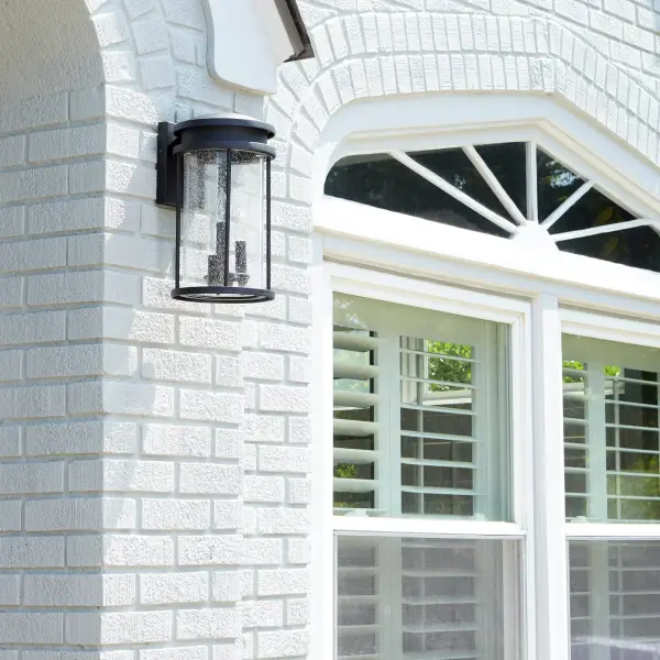 The Hadley outdoor wall light combines clean contemporary lines with practical durability. Its elongated drum silhouette and seeded glass create beautiful ambient lighting while the wet-rated construction ensures reliable performance in any weather. - alternate view