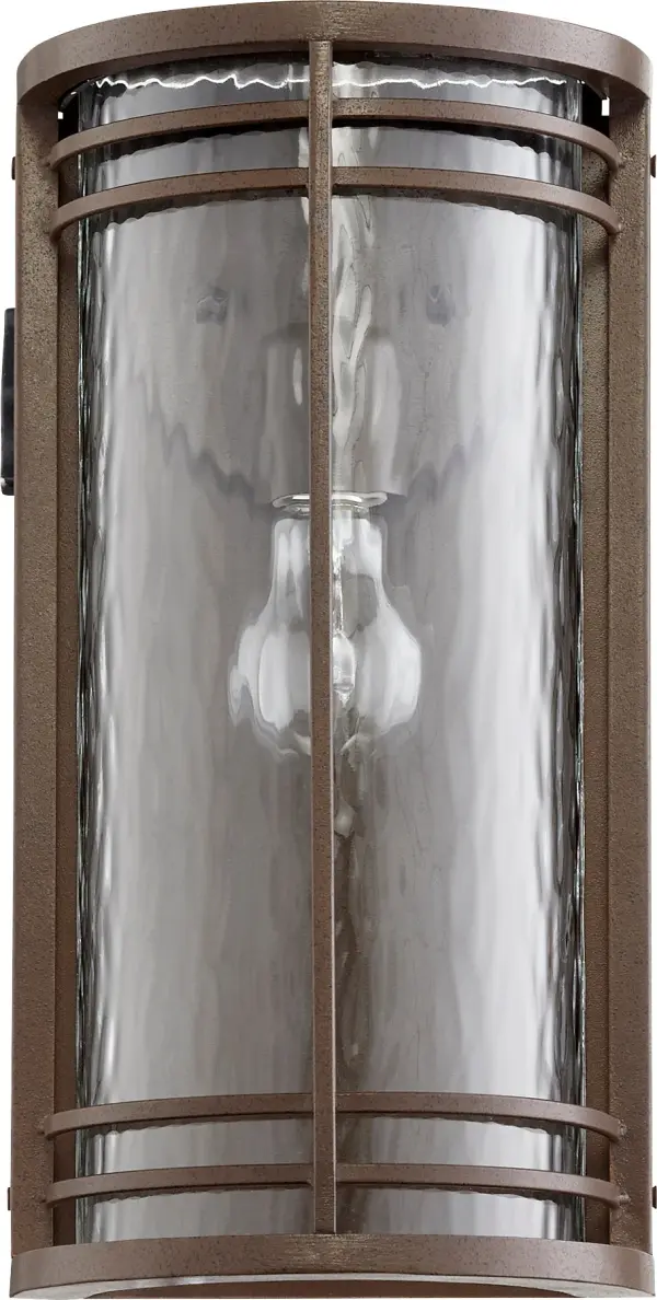 The Larson outdoor wall light combines clean contemporary design with practical functionality. Its elongated drum silhouette and clear hammered glass create beautiful ambient lighting while the wet-listed rating ensures reliable performance in exposed outdoor conditions.