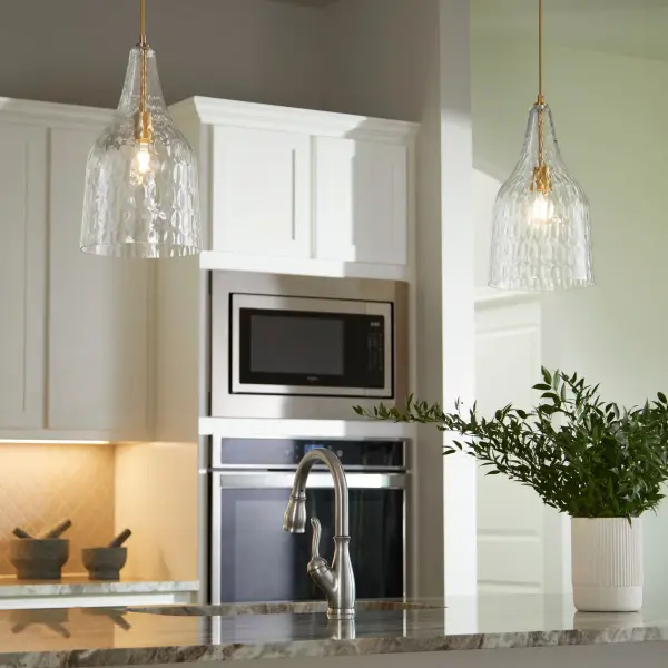 This transitional pendant combines artisanal hammered glass with warm aged brass for a luminous, textured glow. The adjustable 10-foot cord offers installation flexibility for various ceiling heights. - alternate view