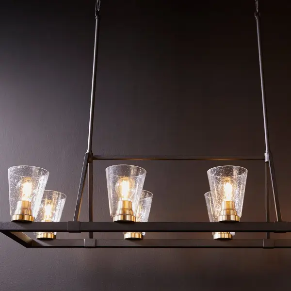 The Paxton combines rustic charm with contemporary geometry in a stunning linear design. Eight exposed bulbs with seeded glass shades create warm ambiance, while the two-tone Noir and Aged Brass finish adds sophisticated contrast. - alternate view