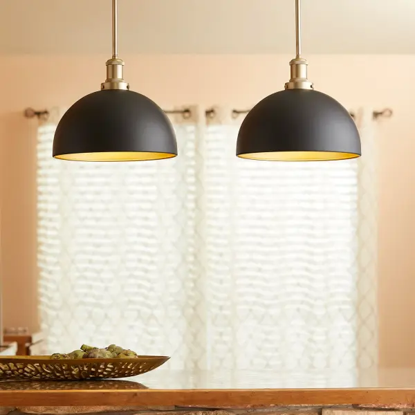 This eclectic pendant combines opaque black exterior with warm aged brass interior and accents, creating visual interest from every angle. The cone shade and decorative cast fitter deliver industrial-modern appeal while maintaining transitional versatility. - alternate view
