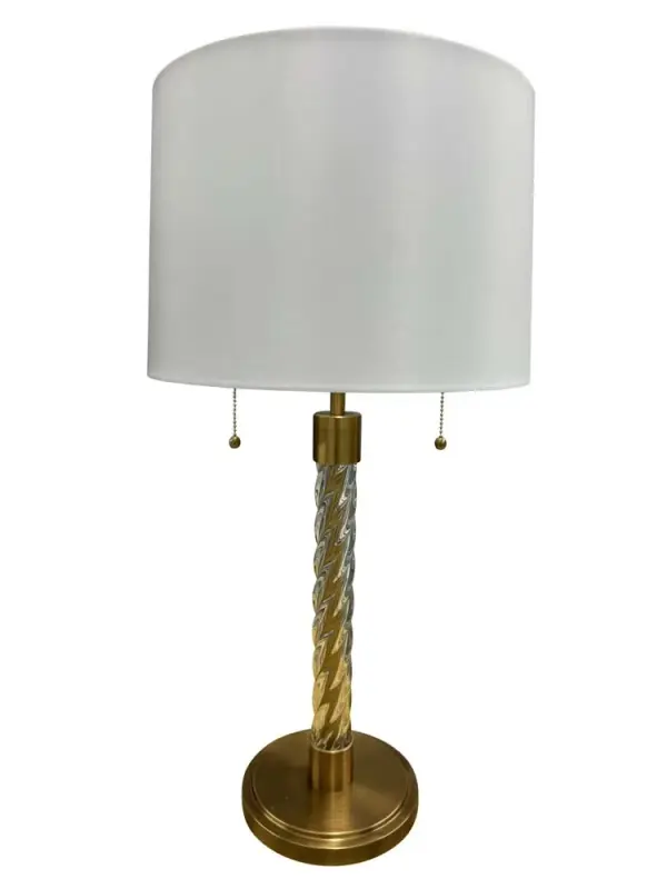 The Chloe table lamp combines a sophisticated glass column base with brushed brass accents and a crisp white linen shade. At 30.5" tall, it makes a statement while providing ample lighting through dual 100W bulbs.