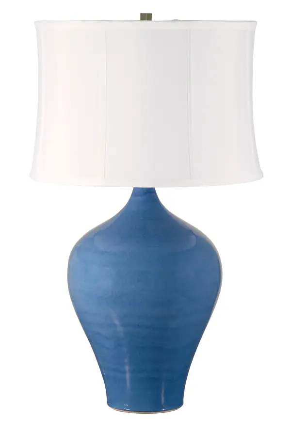 The Scatchard table lamp combines timeless ceramic craftsmanship with a fresh cornflower blue finish. At 25" tall with a generous linen shade, it provides substantial presence and warm ambient lighting for living spaces and bedrooms.