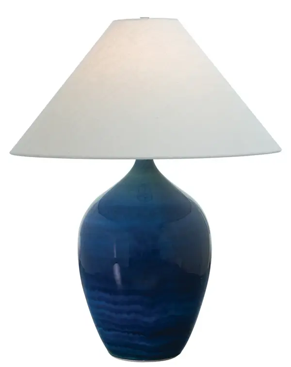 The Scatchard table lamp combines artisanal ceramic craftsmanship with a striking blue gloss finish. At 27" tall with a generous 21" shade, it delivers substantial presence and ambient lighting for living spaces and bedrooms.