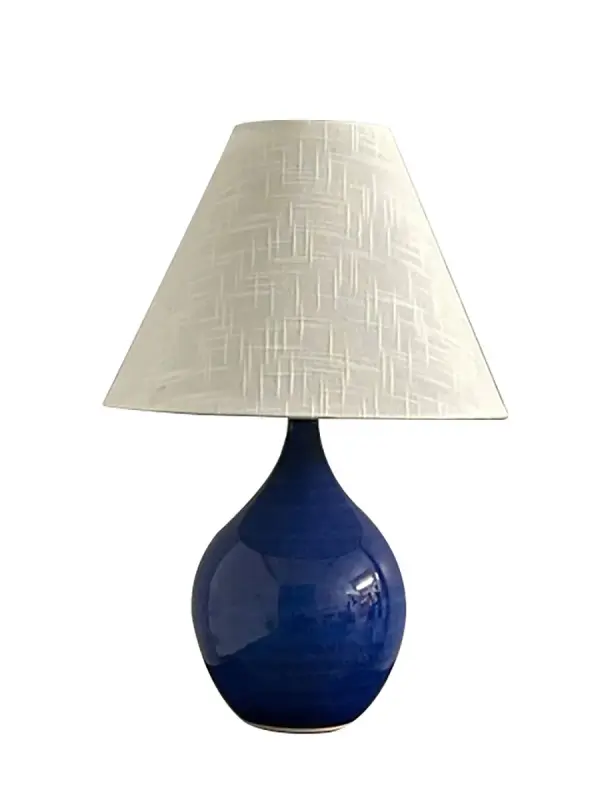 The Scatchard table lamp combines timeless ceramic craftsmanship with a striking imperial blue glaze. Its 19-inch height and cream linen shade create warm, ambient lighting perfect for traditional and coastal-inspired interiors.