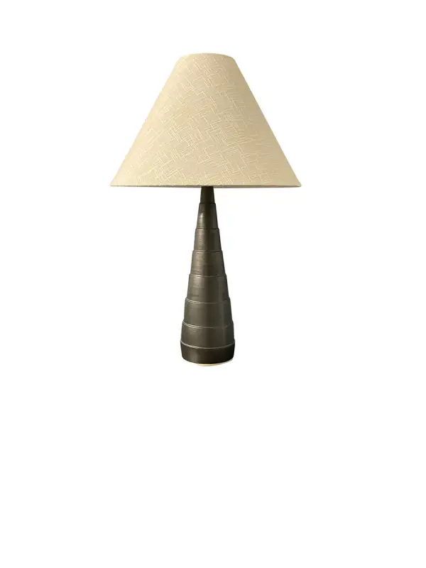 The Scatchard table lamp combines traditional ceramic craftsmanship with a modern matte black finish. At 26.5" tall with a generous 17" shade, it provides substantial lighting and visual presence for living spaces and bedrooms.