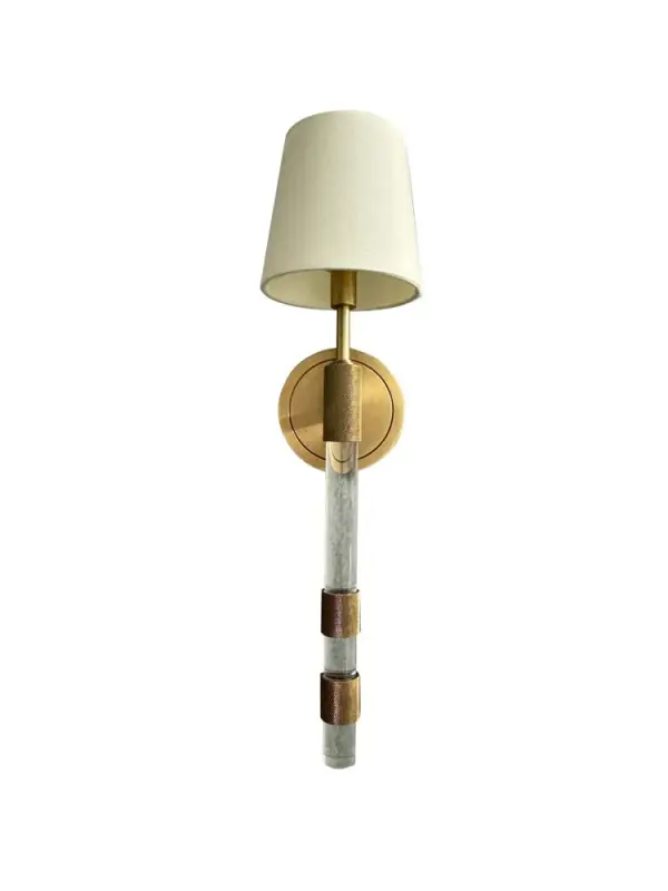 This sophisticated wall sconce combines brushed brass metalwork with acrylic and knurled accents, topped with a classic fabric shade. At 23" tall, it provides substantial presence while maintaining versatility across traditional and contemporary interiors.