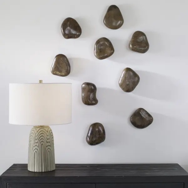 A set of nine solid tamarind wood pebble forms in a rich walnut brown finish, bringing organic texture and natural variation to any wall.