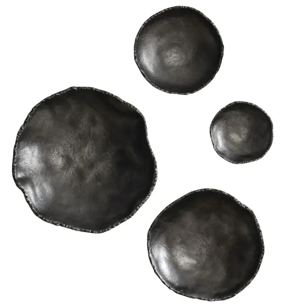 A set of four textural aluminum discs in antiqued nickel, offering organic wall art versatile enough for patios, foyers, or living rooms.