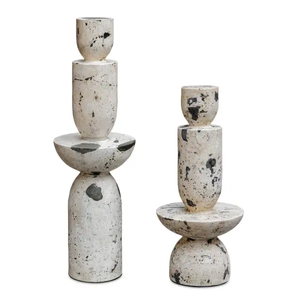 A pair of hand-carved tower sculptures in natural white stone with black resin accents, blending clean geometric lines with organic material for a bold, gallery-like statement.