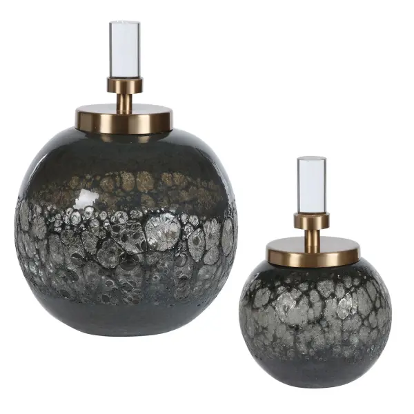 This set of two art glass bottles brings organic texture and an iridescent blue-gray hue, finished with brushed brass lids and crystal accents for understated table styling.