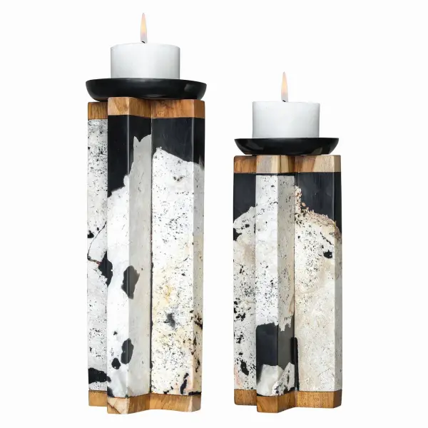 A set of two natural coral stone candleholders with teak wood and black resin accents. Sculptural, organic, and includes matching white candles for instant styling.