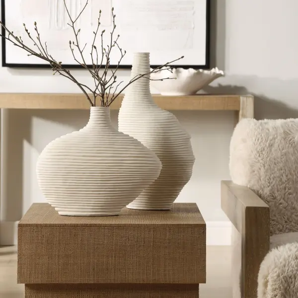 A set of two organically shaped ceramic vases in matte white with a stacked-ring silhouette, offering understated sculptural appeal for shelves, tables, or mantels.