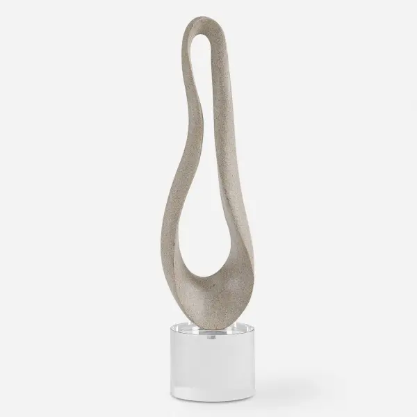 A polyresin sculpture perched on a crystal base, blending organic form with contemporary polish for tabletop display.