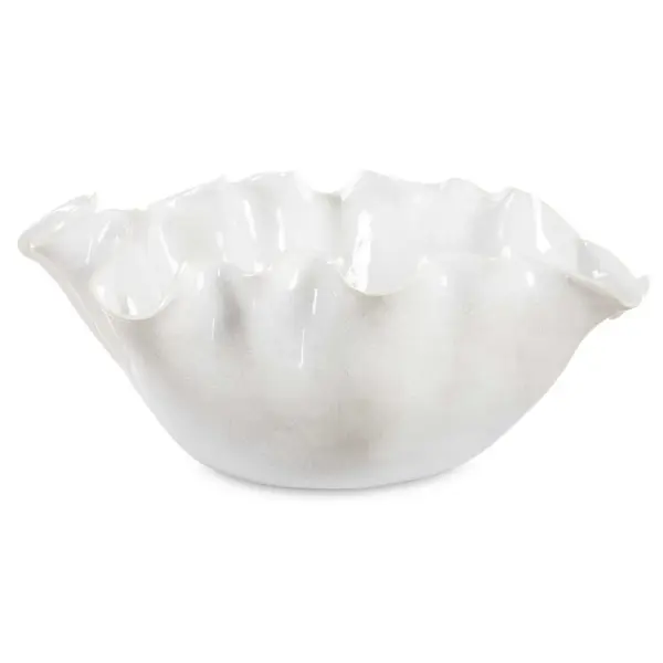 This ruffled ceramic bowl in a crackled white glaze brings soft, organic texture to tabletops as both art and function.