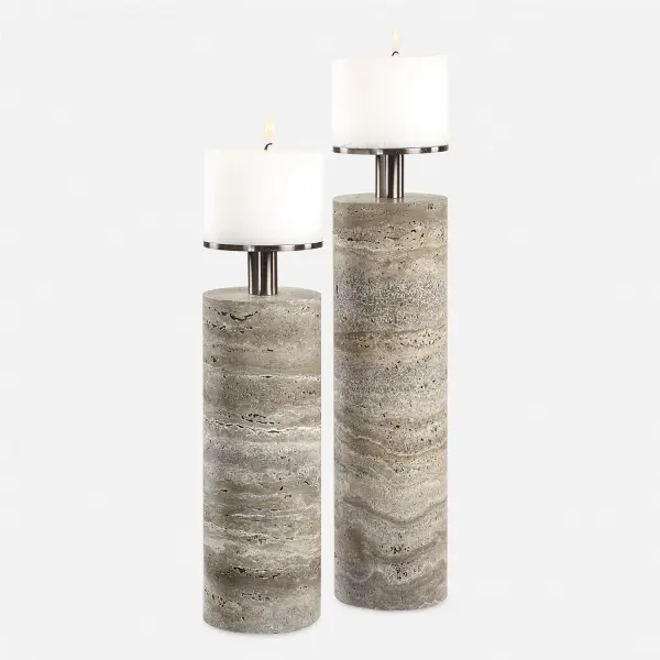 A set of two unfilled gray travertine cylinders with dark bronze candle cups, offering natural stone texture and quiet elegance for tabletop styling.