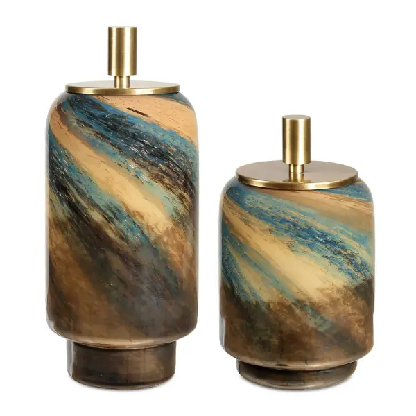 A charming two-piece glass canister set with swirled blue, caramel, and bronze tones topped by brass lift-off lids—equal parts storage and decor.