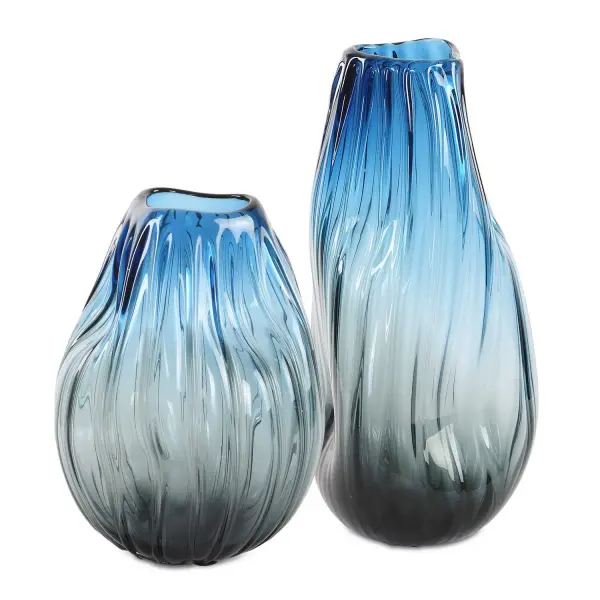 A bold pair of glass vases with a blue-to-black ombre finish and elegant rolled edges—equally stunning with florals or as standalone sculptural accents.