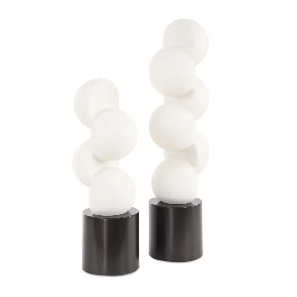 A set of two contemporary hemisphere-stack sculptures on dark bronze cylindrical bases, offering a smooth, minimalist statement piece for modern interior styling.