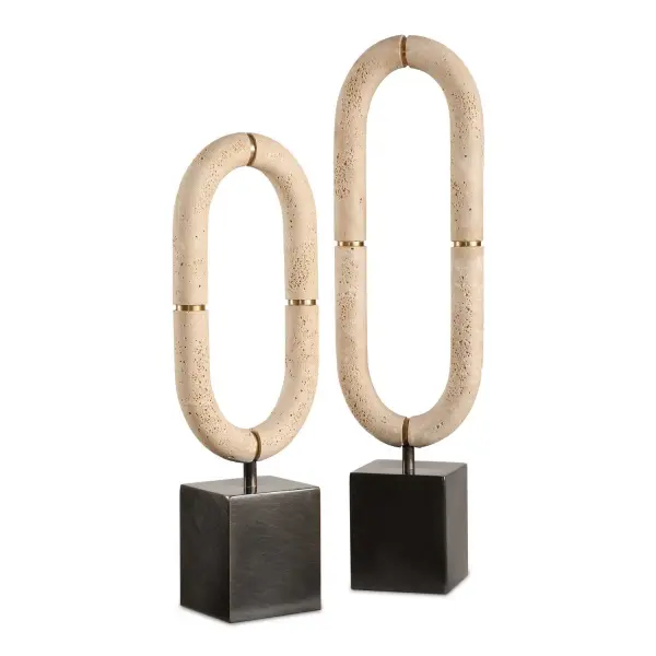 A tabletop sculpture duo pairing cast faux-travertine ovals with dark bronze bases and gold banding—organic, textural, and versatile for shelves or console tops.