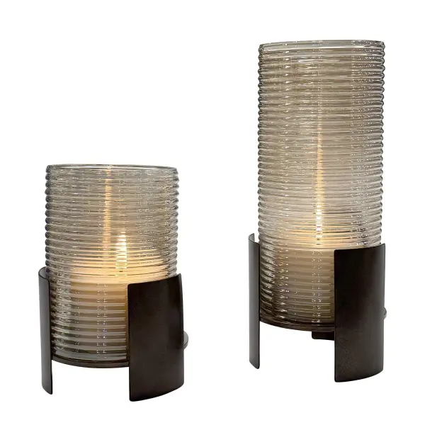 A striking pair of cast iron candleholders with removable ribbed glass cylinders in dark bronze finish. Includes two candles for immediate use.