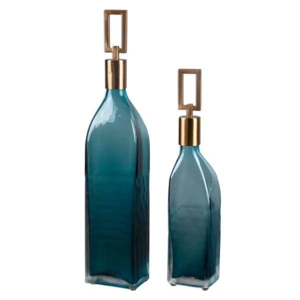 A set of two decorative teal glass bottles with coffee bronze metal stoppers, offering understated artisanal style for shelves, tables, and sideboards.