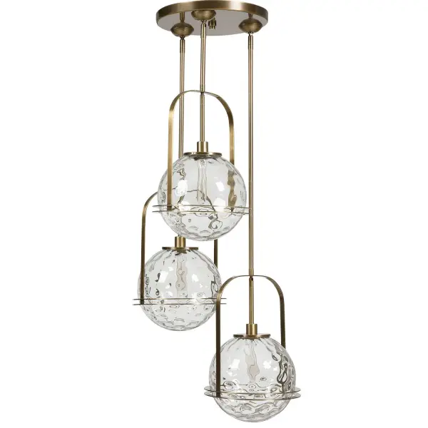 A statement-making three-light pendant pairing warm antique brass with oversized clear watered glass globes in a cascading arrangement for contemporary spaces.