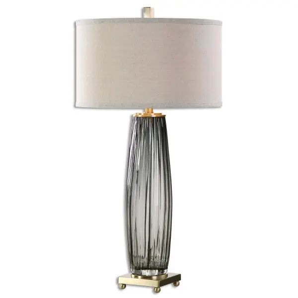 Grooved, Transparent Charcoal Gray Glass Accented With Antiqued Brass Plated Details. The Round Hardback Drum Shade Is A Light Beige With Natural Slubbing. Collection: Vilminore Designer: David Frisch Finish: Antique Brass Glass: Round Hardback Drum Width: 17.00" Height: 33.25" Length: 17.00" Weight: 11.00 lb Number of Bulbs: 1 Maximum Wattage: 150.00 W Bulb Type: A Voltage: 110.00 V Material: Metal, Glass Country of Origin: China Safety Rating: Indoor Only Switch: 3-WAY