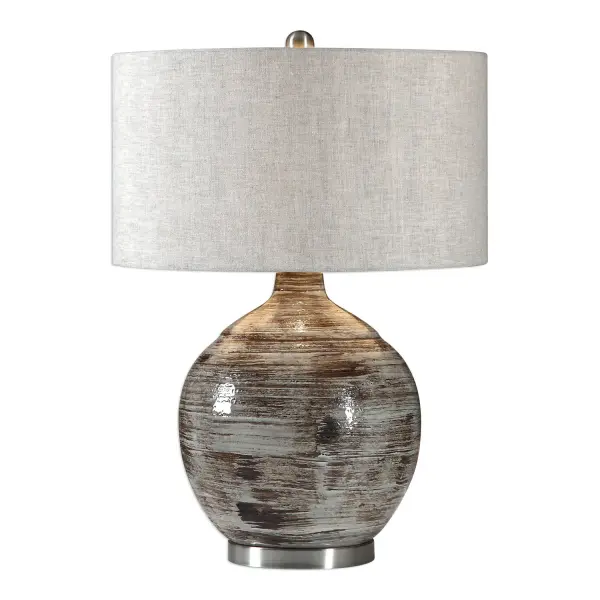 Heavily Textured Ceramic Base Finished In A Distressed Blue-gray Glaze With Rust Bronze Undertones, Accented With Brushed Nickel Plated Details. The Round Hardback Drum Shade Is A Light Beige Linen Fabric With Natural Slubbing. Collection: Tamula Designer: Jim Parsons Finish: Brushed Nickel Glass: Round Hardback Drum Width: 19.00" Height: 27.00" Length: 19.00" Weight: 12.32 lb Number of Bulbs: 1 Maximum Wattage: 150.00 W Bulb Type: A Voltage: 110.00 V Material: Ceramic & Iron Country of Origin: China Safety Rating: Indoor Only Switch: 3-WAY